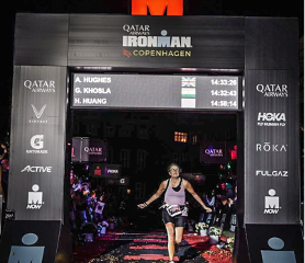 Alison crossing the Ironman finish line